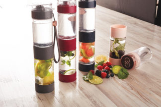 Infuser bottles with various fruits are placed on a wooden table