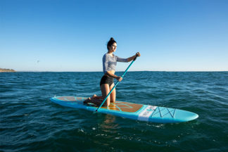 woman practices standing on sup