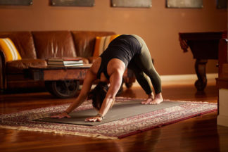 A woman performs downward dog.