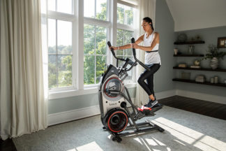 Woman uses elliptical in home