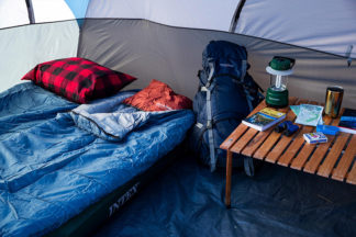 An inside of a tent featuring sleeping bags and a small table