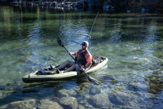 A man sits in a fishing kayak.