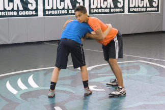 Two wrestlers demonstrate a body lock throw.