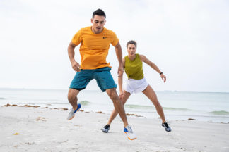 man and woman working out on the beach