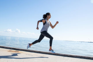 woman running on pier near water