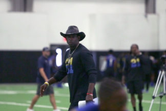 Deion Sanders Coaching Football Players On Indoor Football Field