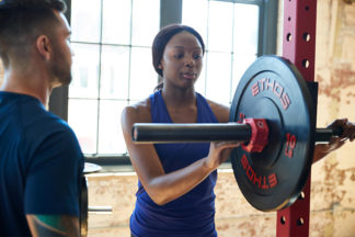 Woman Putting Clip On Barbell To Secure Weight