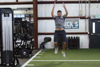 Man Performing Broad Jump Exercise In Gym