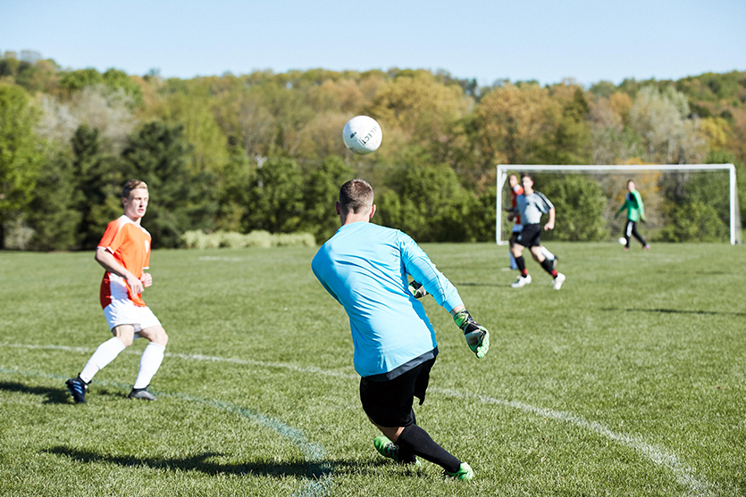 male soccer players playing on soccer field