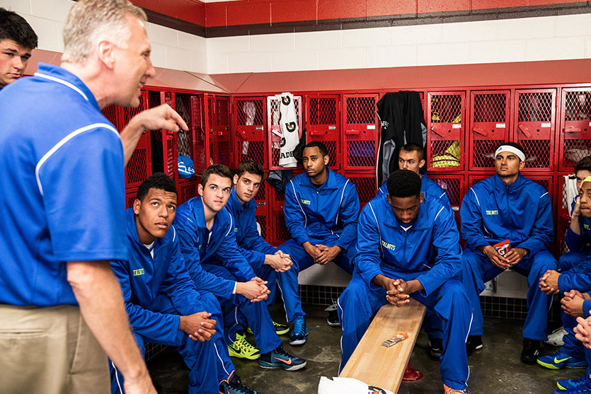 basketball coach motivating a team in the locker room before a basketball game