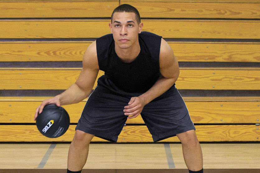 basketball player dribbles a weighted basketball in a basketball gym
