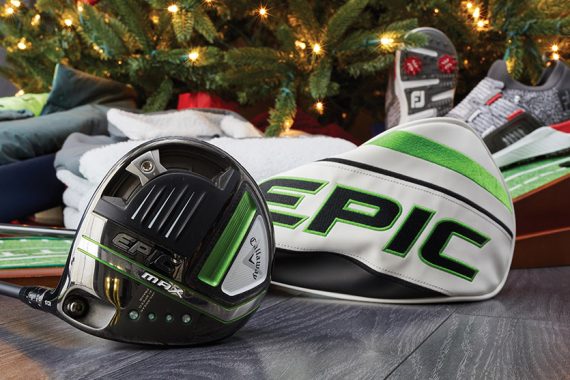 Image features golf gifts by a Christmas tree.
