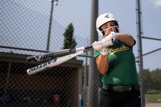 Image features softball player holding bats