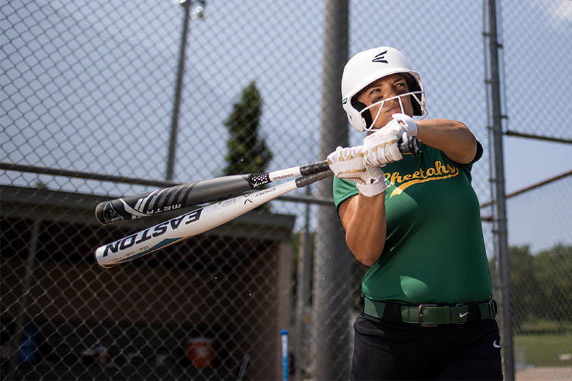Image features softball player holding bats